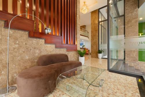 a lobby with a chair and a glass table at Minh Tuyết Luxury Hotel in Nha Trang
