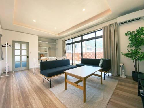a living room with a couch and a table at カモゲストハウス ペット不可 in Tsuruoka
