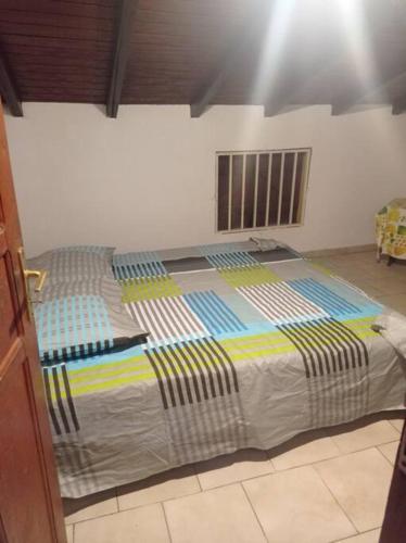 ein großes Bett in einem Zimmer mit Fenster in der Unterkunft La Cour CoCoyer in Bouillante