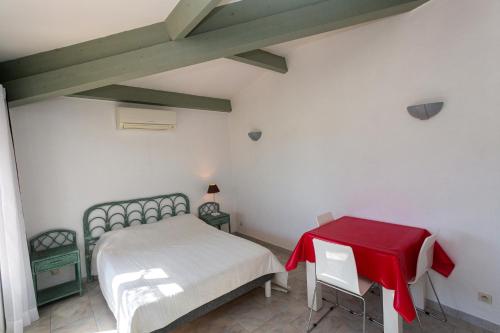 a bedroom with a bed and a red table at Résidence Padro in Calvi