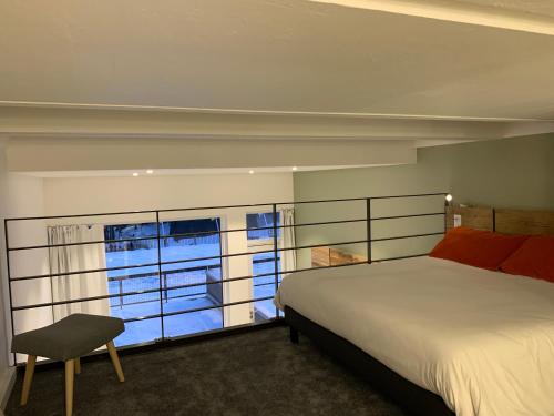 a bedroom with a bed and a large window at Flaine Forum H1 Cassiopée Mezzanine & Terrasse in Flaine