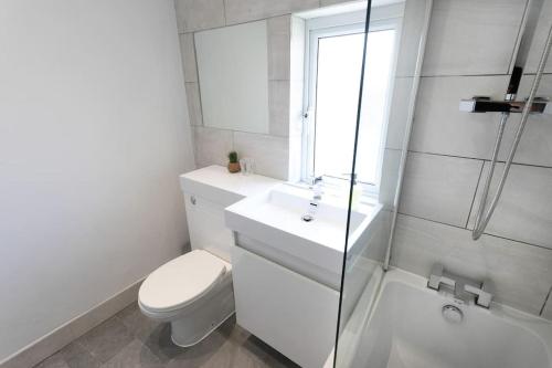 uma casa de banho branca com um WC e um lavatório em *Contractors, Holidays, Races, 25% off long stays* em Cheltenham