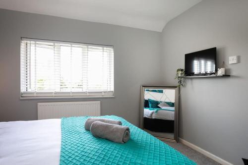 um quarto com uma cama com um cobertor azul e um espelho em *Contractors, Holidays, Races, 25% off long stays* em Cheltenham