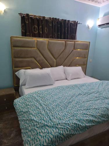 a bedroom with a large bed with a wooden headboard at Dazzle hotels and apartments in Jidu