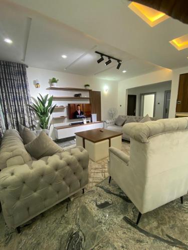 a living room with two couches and a table at Dazzle hotels and apartments in Jidu