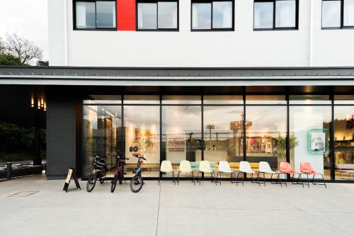 two bikes parked in front of a building at SETOUCHI KEIRIN HOTEL 10 by Onko Chishin in Tamano