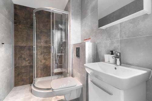 a bathroom with a toilet and a sink and a shower at Kamienica Centrum Apartament 18 in Szczecin