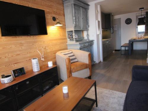 - un salon avec un canapé et une télévision murale dans l'établissement Appartement 3 pièces, 6 pers, 45m² - Couv.piscines, prox.pistes et écoles ski, parking, balcon, WiFi - FR-1-405-161, à Huez
