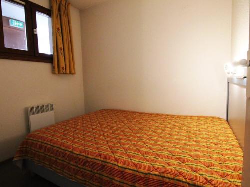 - une chambre avec un lit et une couverture orange dans l'établissement Appartement cosy 4 pers, proche pistes et commerces, balcon est, animaux ok, Huez - FR-1-405-155, à L'Alpe-d'Huez