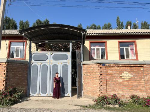 uma mulher à porta de uma casa em Bayzak guest house 