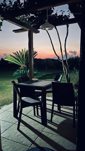 a table and chairs sitting under an umbrella at B&B Casale Pietrantica Tropea in Ciaramiti