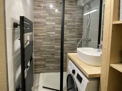 une salle de bain avec un lavabo et une machine à laver dans l'établissement Duplex 3 pièces pour 6 personnes avec balcon, WIFI à L'Alpe d'Huez - FR-1-405-229, à Huez