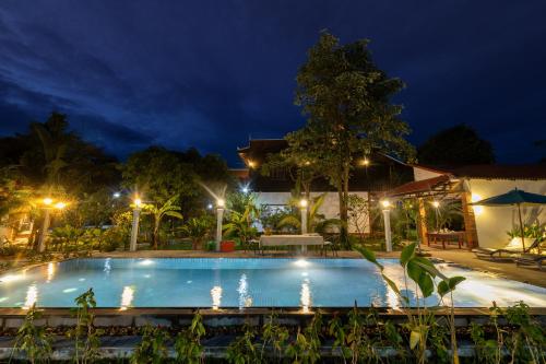 - une piscine éclairée la nuit dans l'établissement Atoh's Maison, à Siem Reap
