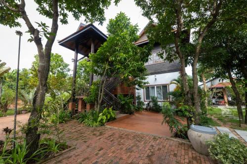 a house with a brick driveway in front of it at Atoh's Maison in Siem Reap