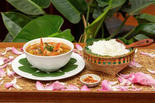 a bowl of soup and rice on a table at Atoh's Maison in Siem Reap