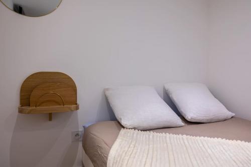 a bed in a room with two pillows on it at L'Écrin De L'Hyper Centre in La Rochelle