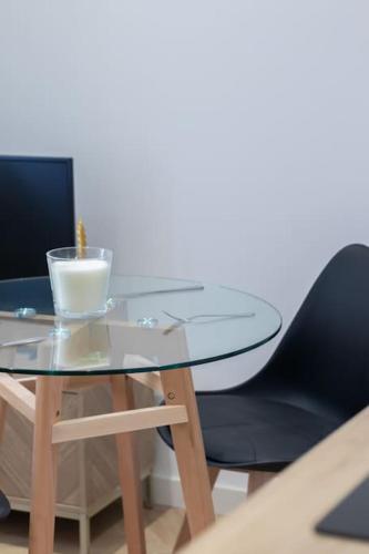a glass table and a chair with a bowl on it at L'Écrin De L'Hyper Centre in La Rochelle