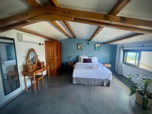 a bedroom with a bed and a desk with a mirror at La Caze Grande Anse in Petite Île