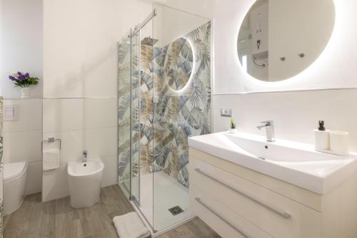 a bathroom with a sink and a toilet and a mirror at Quarzo. Modern Rooms in Cagliari