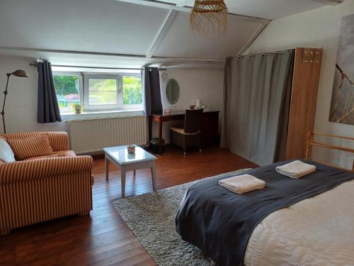 - une chambre avec un lit, un canapé et une table dans l'établissement Les Gabelous - chambre d'hôtes - Viroinval, à Dourbes