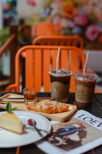 a table with a plate of food and two cups of coffee at Sidewalk Boutique Hotel in Ko Samed