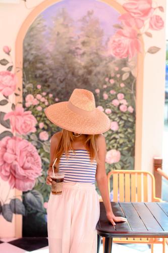 a young girl wearing a straw hat sitting on a table at Sidewalk Boutique Hotel in Ko Samed