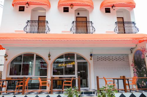 a restaurant with orange chairs in front of a building at Sidewalk Boutique Hotel in Ko Samed