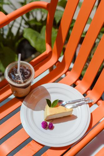 a plate with a piece of cake and a drink at Sidewalk Boutique Hotel in Ko Samed