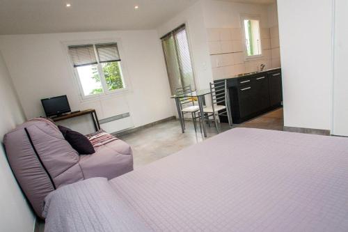 a room with a bed and a couch and a kitchen at Résidence Padro in Calvi