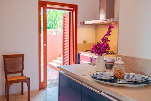 a kitchen with a vase of flowers on a counter at Tenuta Delle Ripalte in Capoliveri