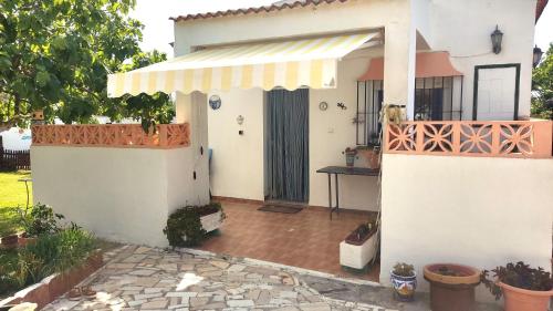 Cette maison blanche dispose d'un auvent et d'une terrasse. dans l'établissement Casa con piscina privada y jardín, à Chiclana de la Frontera