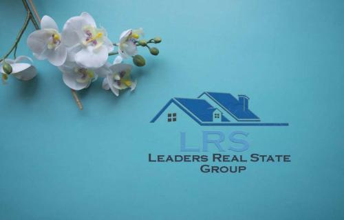 a sign for a leaders real estate group with flowers at SAN STEFANO in Alexandria