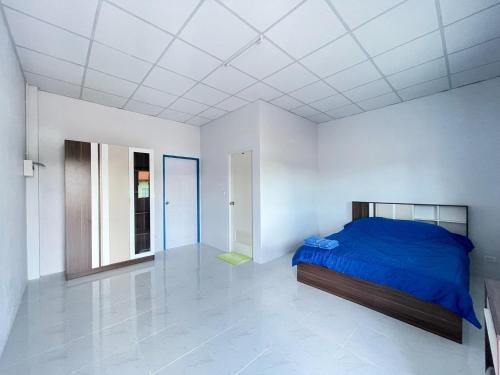 1 dormitorio con 1 cama azul en una habitación blanca en Aviator Club Restaurant & Resort, en Ban Khong Krathin