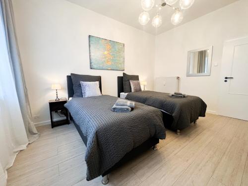 a bedroom with two beds and a painting on the wall at Apartment Düsseldorf City in Düsseldorf