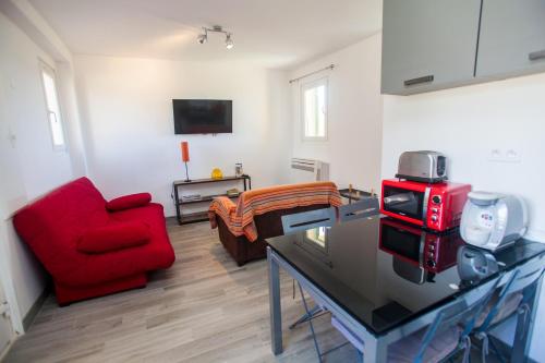 a living room with a red chair and a red stove at Résidence Padro in Calvi