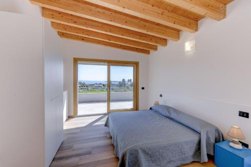 a bedroom with a bed and a large window at Villa Easy Life by Garda FeWo in Moniga