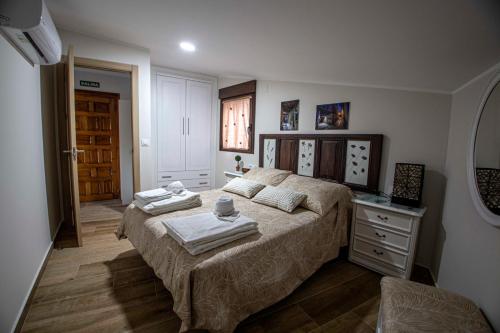 1 dormitorio con 1 cama con toallas en AT la Abuela Antonia-El Gurugú, en Torre de Don Miguel