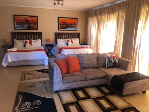 a living room with a couch and two beds at JC Studios Ermelo in Ermelo