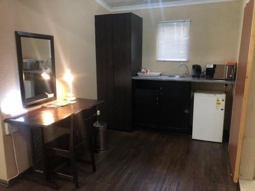 a kitchen with a desk and a sink and a mirror at JC Studios Ermelo in Ermelo
