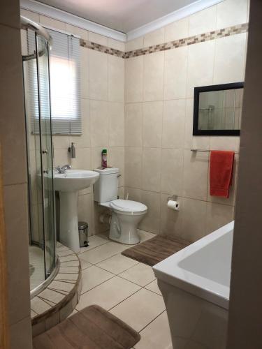 a bathroom with a sink and a toilet and a tub at JC Studios Ermelo in Ermelo