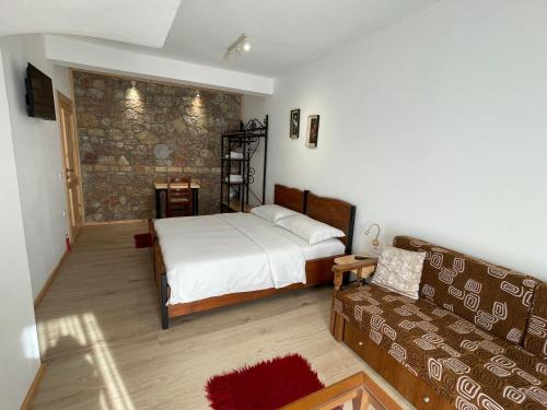 a bedroom with a bed and a couch at Bujtina Liana Voskopoje in Voskopojë
