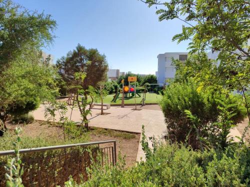 a park with a playground with a swing at Appartement avec piscine taghazout imi Ouaddar in Agadir nʼ Aït Sa
