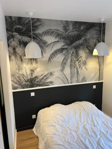um quarto com um mural preto e branco de palmeiras em Le petit cocoon em Merlimont