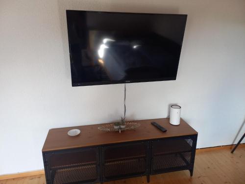 a flat screen tv hanging on a wall with a table at Lechapart Wagner in Reutte