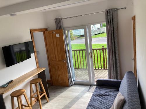 a living room with a couch and a sliding glass door at F17 Rickardos Holiday Lets in Mablethorpe