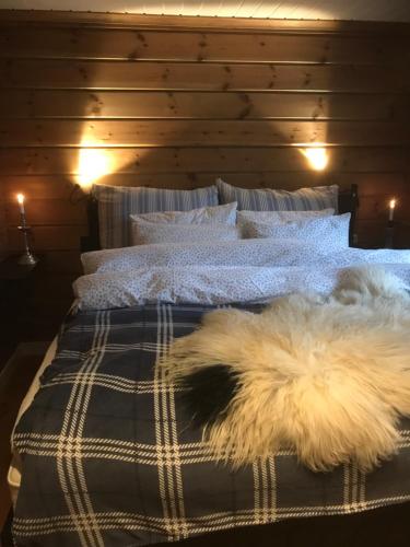 a white dog laying on a bed in a bedroom at Remestøylflotti Hyttegrend in Hovden