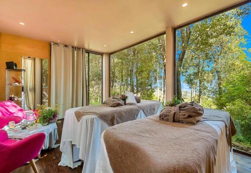 two beds in a room with a large window at Villa Experience - Relais Il Termine Elba in Rio Marina
