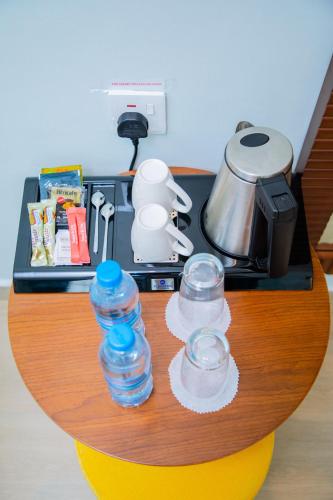 a counter with two glasses and a pot on a stove at Best Western Dodoma City Hotel in Dodoma