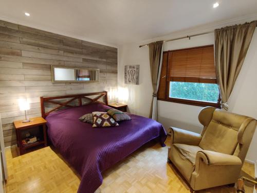 a bedroom with a purple bed and a chair at Villa Jupperi Espoossa in Espoo