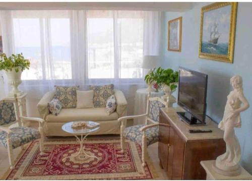 a living room with a couch and a tv at Attico una finestra sulle Isole Eolie in Brolo